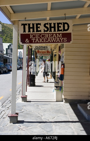 Signboards hanging from old timber buildings now shops in main street historic former goldrush town of Arrowtown New Zealand Stock Photo