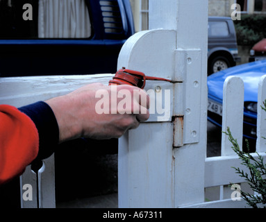 Oiling a steel garden gate hinge. Stock Photo