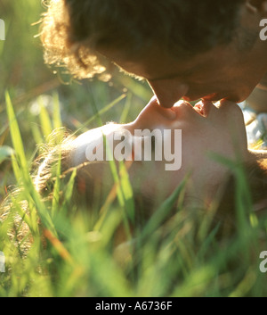 Couple kissing in grass closeup Stock Photo