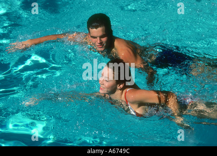 Couple swimming in resort pool Stock Photo