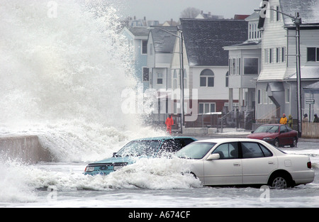 Vehicles are stalled in flood waters as giant waves crash on a seawall during a winter storm in Massachusetts Stock Photo