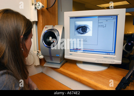 A security employee demonstrates the use of an iris scanning identity device being tested at Logan Airport in Boston Stock Photo