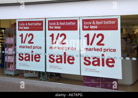 High street shop window with January sales banner posters advertising half price sale Stock Photo