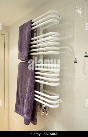 Bathroom shower room central heating towel rail tubes for room heating & towels warm & dry fixed to white glazed wall tiles light pull cord England UK Stock Photo