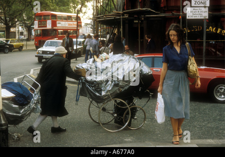 Homeless woman pushing her prams through the streets of Chelsea,  London Stock Photo