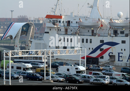Cross Channel ferry with bow doors open Port of Calais northern France Cars caravans vechicles wait on the dockside to embark Stock Photo