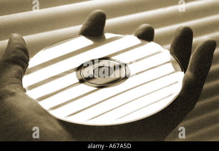 Information Hand holding computer CD disc Stock Photo
