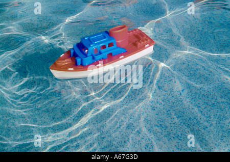 Toy plastic boat in swimming pool water toys boats boating Stock Photo