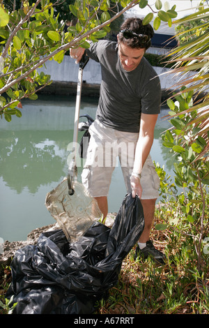 Miami Beach Florida,Collins Canal,community volunteer cleanup,Hispanic man men male,trash,litter,bag,bags,FL070310012 Stock Photo