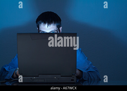 Businessman Using Laptop Working Late Into the Night Stock Photo