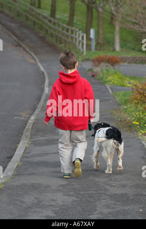 Young boy aged 10 years walking pet dog Stock Photo
