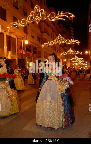 Falleras in traditional Valencian costume during L'Ofrena de flors flower offering march during Las Falles festival held in Valencia city Spain Stock Photo