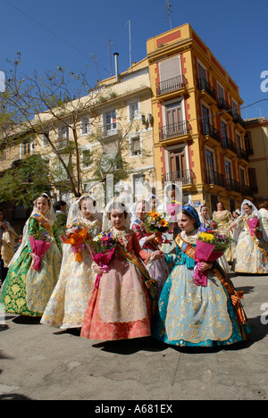 Falleras in traditional Valencian costume marching in the street during Las Falles traditional festival held in the city of Valencia Spain Stock Photo