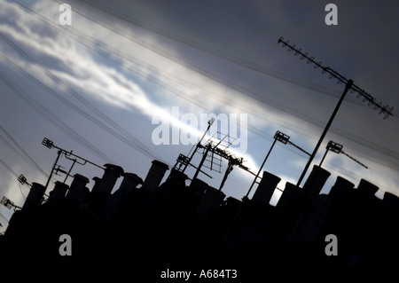 A roofscape with chimney pots and tv aerials at dusk  in a quiet Victorian terraced back street in the city of Brighton and Hove Stock Photo