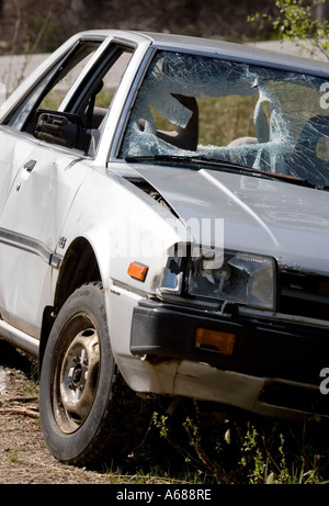 Silver colored abandoned and vandalised sedan at roadside , Finland Stock Photo