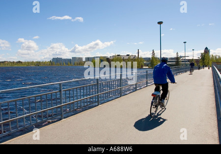 Man biking on a Merikoski bridge that crosses the River Oulujoki Oulu  Finland Stock Photo