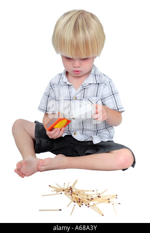 Young boy playing with a box of safety matches on a white background Stock Photo