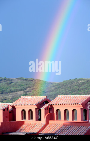 Close colourful rainbow falling on building after heavy rain storm Stock Photo