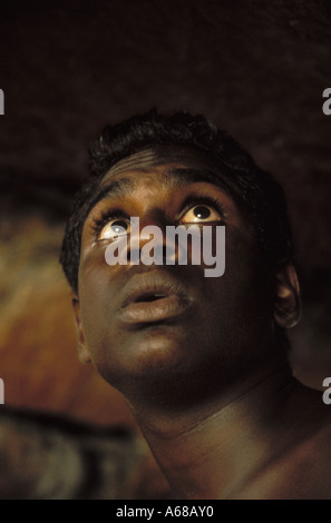 Awestruck aboriginal boy Sean in rock shelter Arnhem Land Stock Photo