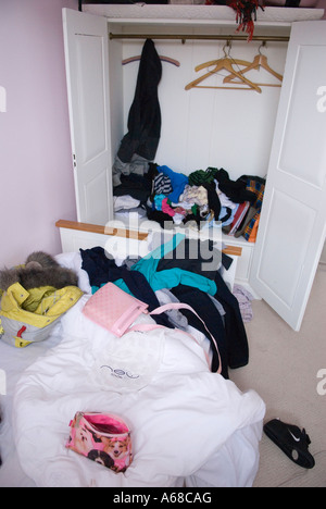 Teenagers untidy messy bedroom UK. Teen girl, fifteen years old bed room and unmade bed, cupboard Nothing hung up, just dumped 2000s UK HOMER SYKES Stock Photo