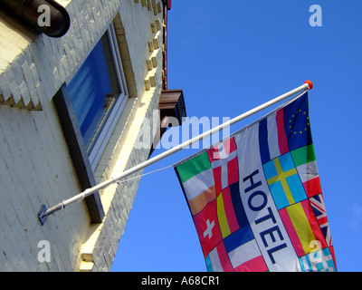 international welcoming flag on pole outside Hotel Stock Photo