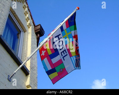 international welcoming flag on pole outside Hotel Stock Photo