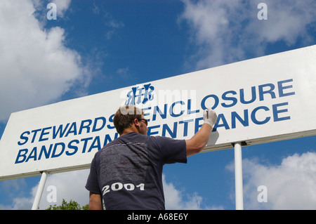 Sign writer painting  the signs before  the Henley Royal Regatta- the Stewards Enclosure Stock Photo