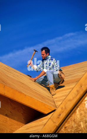 Construction worker on roof of new house construction Stock Photo
