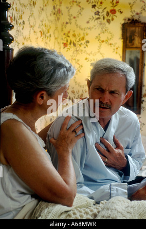 Man s hand holding chest as if suffering from chest pains or heart attack Stock Photo