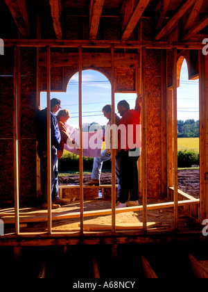Worker review the schematic during the construction of a new house Stock Photo
