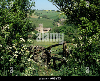 View over stile to village of  Naunton, Gloucestershire, Cotswolds, England. Stock Photo