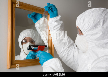 Crime scene officer lifting ear print from a mirror Stock Photo