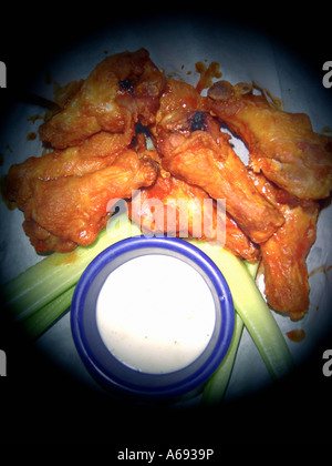 Spot Lit Plate of Hot and Spicy Buffalo Chicken Wings Celery and Bleu Cheese Dressing Viewed From Above Copy Space Stock Photo