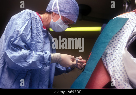 Epidural being given to a woman for pain relief during childbirth Queen Charlottes Hospital London Stock Photo