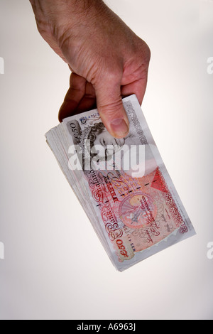 Hand holding fan of twenty 50 pound notes Stock Photo