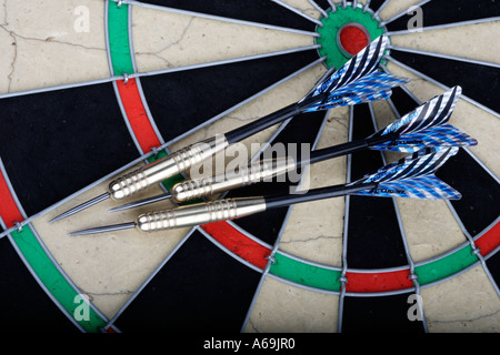 Three darts on a dartboard Game of throwing darts at a target Stock Photo