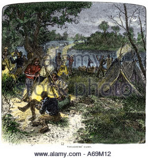 Riverside camp of voyageurs or French fur traders in North America. Hand-colored woodcut Stock Photo