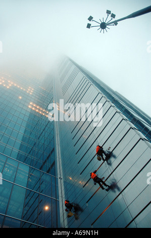 Window washers hanging on a rope, cleaning windows of Rondo 1 office block in Warsaw, Poland Stock Photo