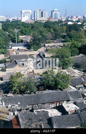 China, Beijing, rooftops of traditional, crowded courtyard housing, with modern city in background, elevated view Stock Photo