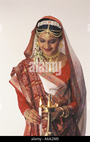 VDA77156 Gujarati Bride Dressed In Traditional Bridal Costume Mid Shot Lighting A Lamp MR#121 Stock Photo