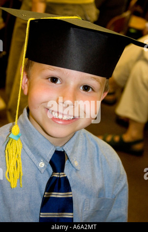 Boy age 6 wearing a mortar board for graduation from kindergarten. Horace Mann Elementary School St Paul Minnesota USA Stock Photo