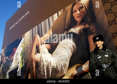 A security guard stands in front of a Gucci billboard in Beijing, China. 14 Dec 2005 Stock Photo