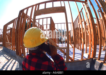 worker on cell phone at construction site of new home Stock Photo