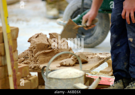 British bricklayer London mixing mortar UK apprentice building site Stock Photo
