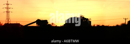 Panoramic of a factory silhouetted against an orange sky, Lostock Works Lane, Northwich, Cheshire UK Stock Photo