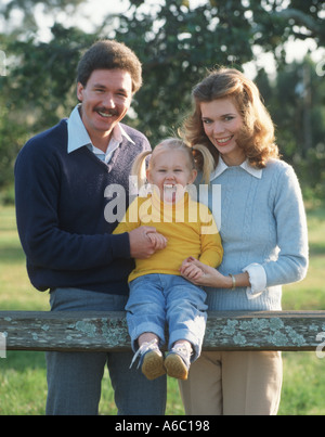 Family of three by wooden fence Stock Photo