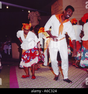 Local man in white and orange costume dancing with woman during cultural folk show held in Willemstad Curacao The Caribbean Stock Photo