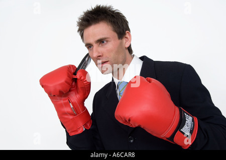 when the going gets tough the tough get going punching your weight business concept businessman in boxing gloves on the phone Stock Photo