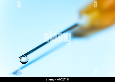 Hypodermic needle with drop of fluid at tip Stock Photo