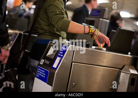 Young woman takes ticket from ticket barrier Stock Photo
